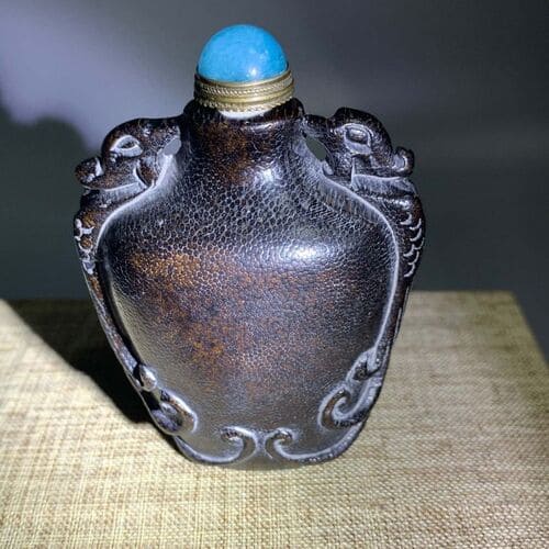 Vintage hand-carved bone snuff bottle with intricate details made from ox horn and rhino horn.