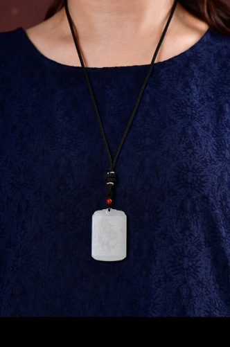 Hotan Jade - Armonia del drago e della fenice】 Ciondolo di buon auspicio del drago e della fenice in giada naturale di Hotan - scolpito a mano (5) Uomo che indossa la collana Hotan Jade Dragon Phoenix Pendant, con stile e dimensioni eleganti.